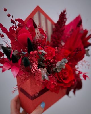 Elegantní aranžmá stabilizovaných květin v červených tónech, umístěné v dekorativní krabičce ve tvaru obálky. Obsahuje...
